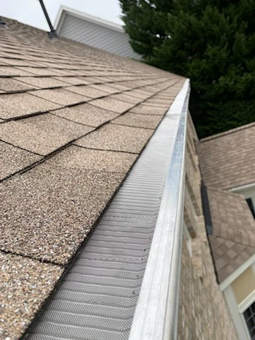 Fine micro-mesh gutter guard along a roof eave